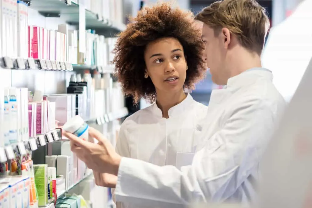 Pharmacists discuss new medication attributes and side effects in pharmacy.