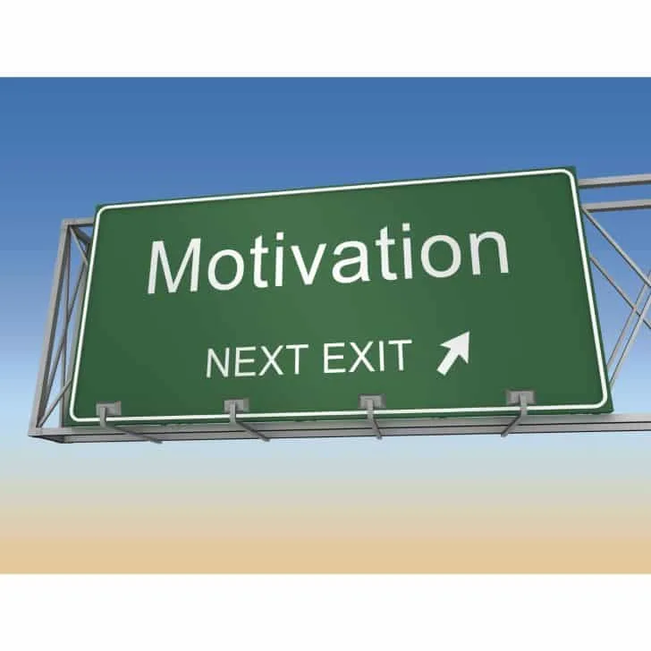 Green motivation exit here sign with and arrow, blue sky in the background.